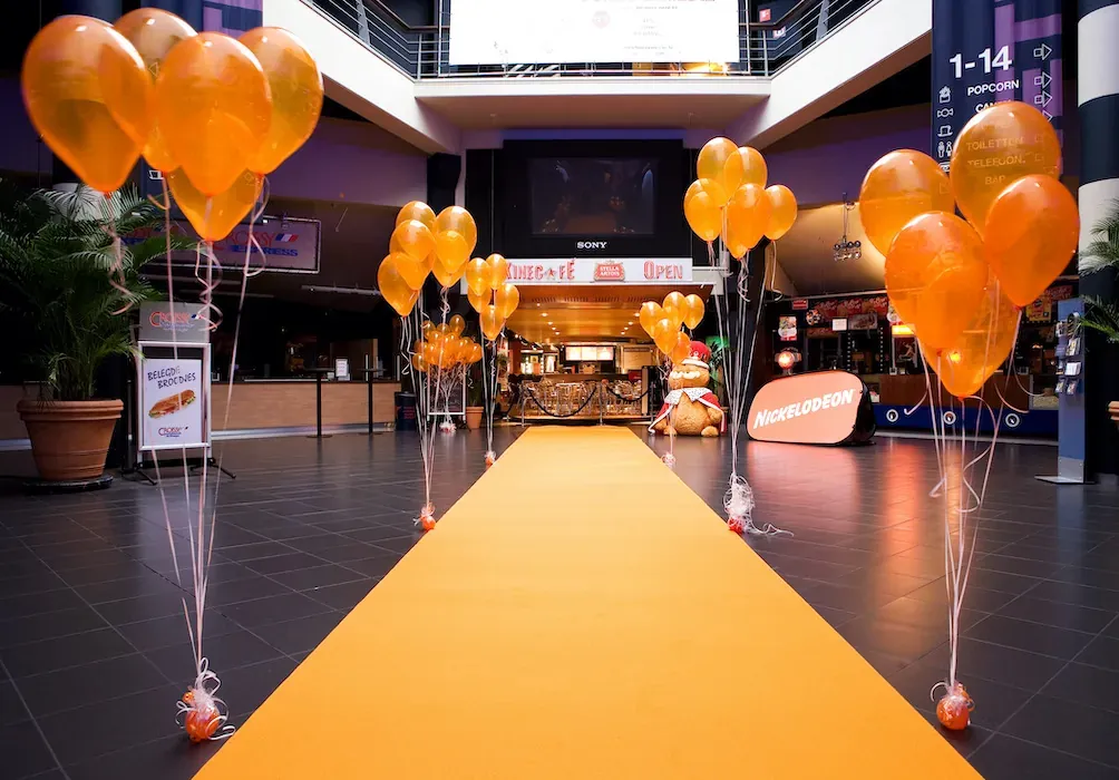 Carpet Drizzle, orange runner through a decorated cinema foyer