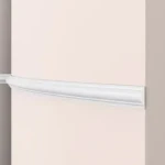 Plain concave cornice moulding, white profile against a terracotta wall