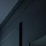 Plain concave cornice moulding, white profile against a terracotta wall