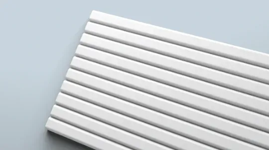 Fluted wall panel with flat-topped ribs under raking light