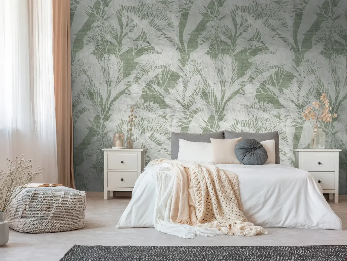Wall mural Grisaille with green and grey foliage behind a bed