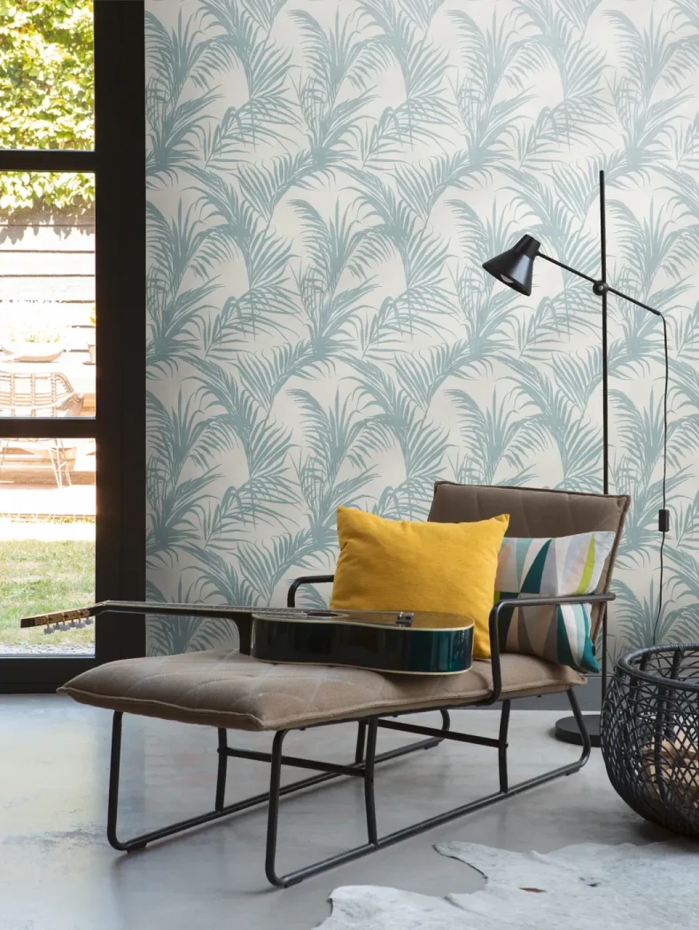 Wallpaper Tourmaline with blue-green palm leaves behind black furniture