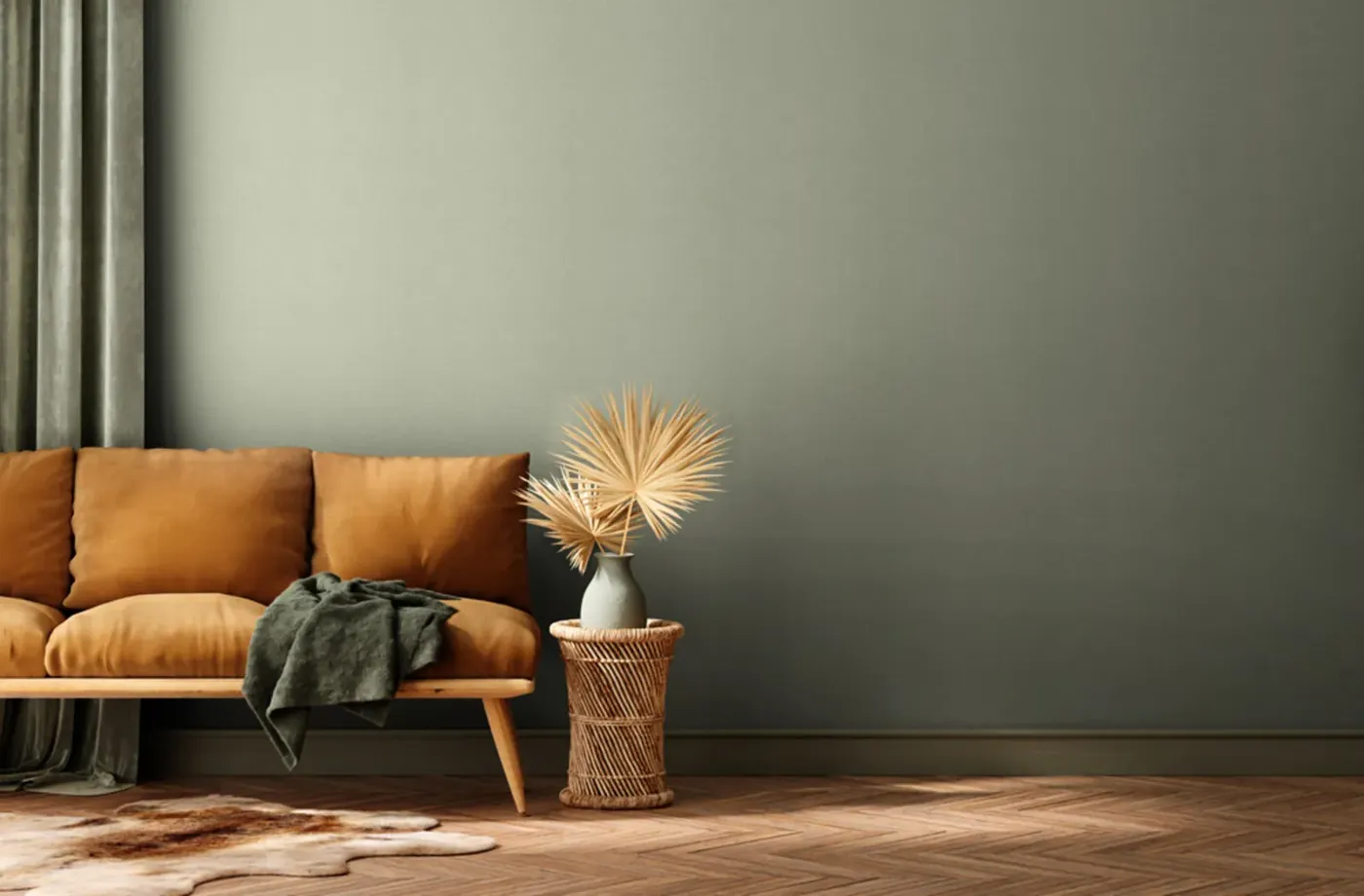Wallpaper Deep Tan, sage green wall behind an ochre velvet sofa