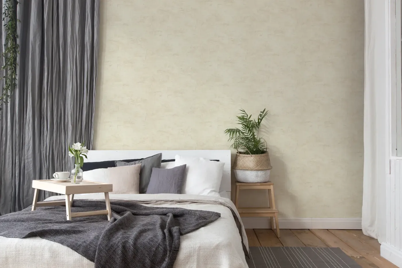 Wallpaper Ash Flint, light grey grained wall behind a bed